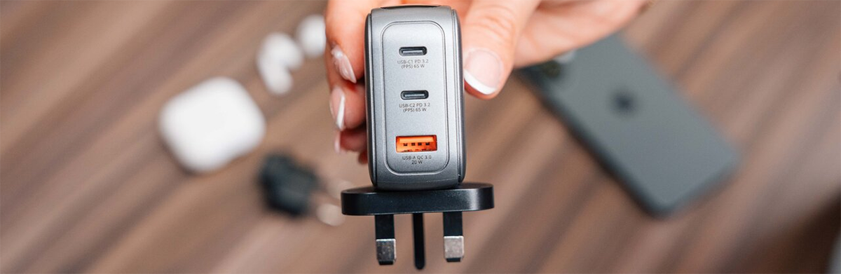 Mini GaN charger held in hand with plug outlet attachment connected.