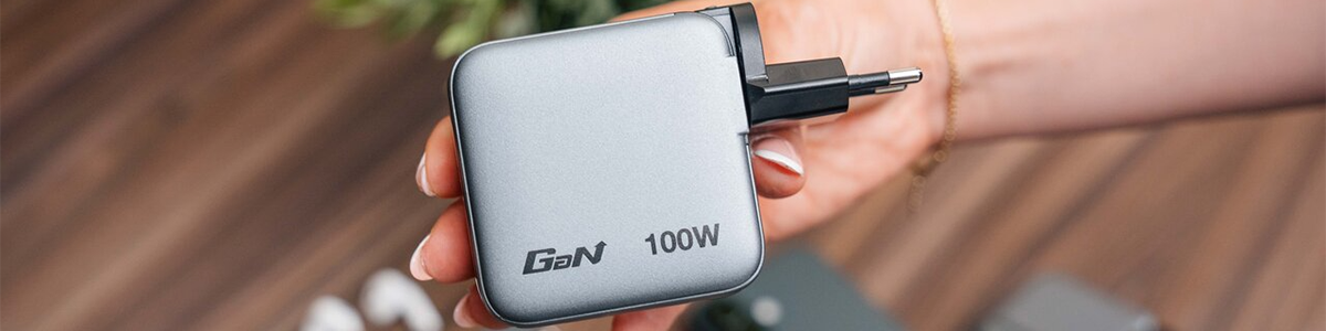 Mini GaN charger held in hand with plug outlet attachment connected.