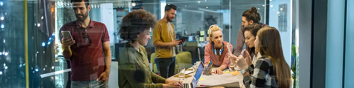 Office scenario of people using various tech.