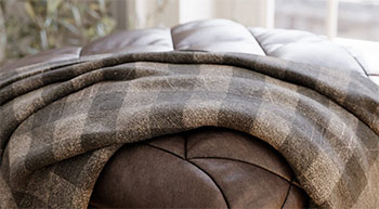 Rendered material preview of chequered blanket on leathher couch