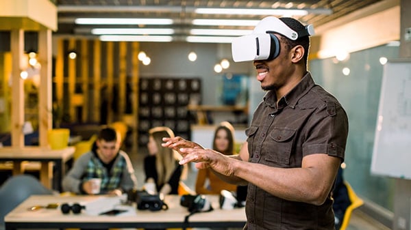 a man wearing a virtual reality headset in a office