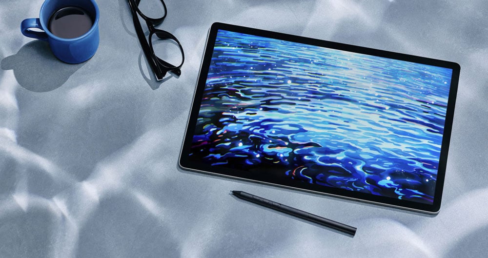 wacom tablet next to a pair of glasses and a coffe cup