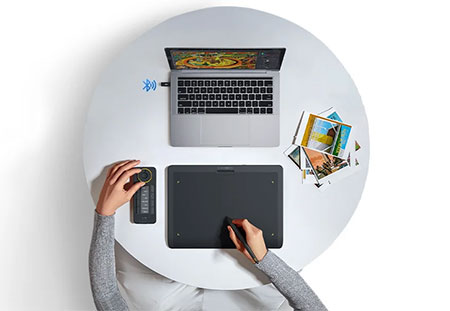top down view of someone sat at a circular table using the xencelabs tablet connected to a laptop
