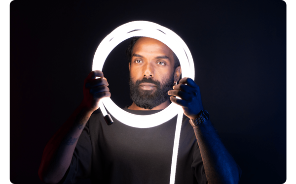 Person holding Atomos Sun Dragon in loop infront of their face illuminated white