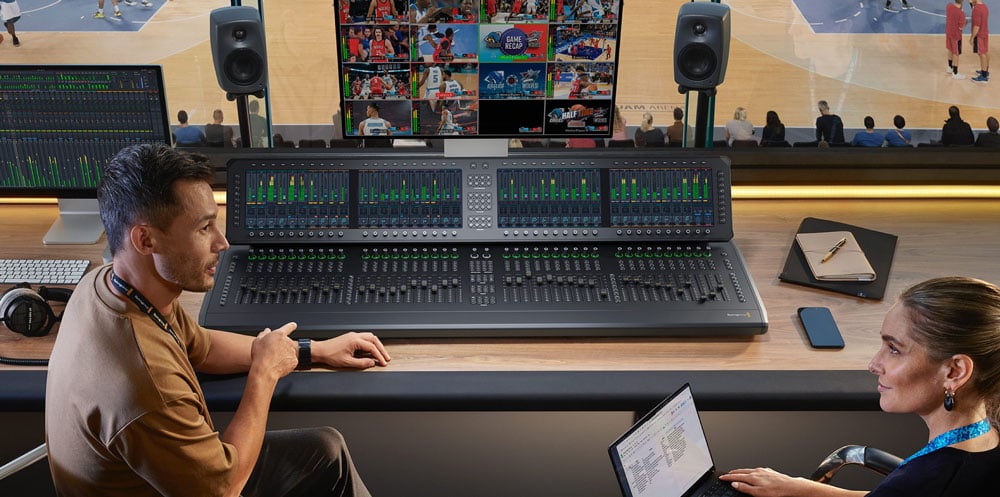 two people in a sound studio during a basketball game using the blackmagic fairlight live audio panel