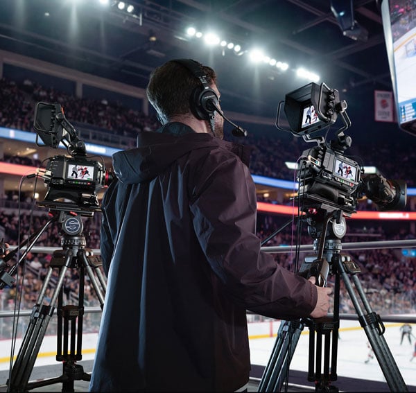 someone filming a hockey game using a blackmagic camera