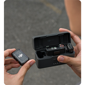 person removing DJI Mic 2 from charging case