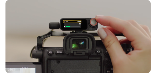 person using dji mic 2 receiver control dial when mounted to mirrorless camera video rig