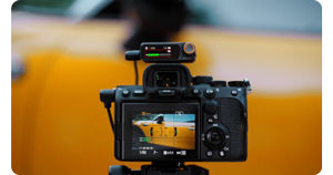 DJI mic 2 receiver mounted on camera shooting video of yellow taxi cab 