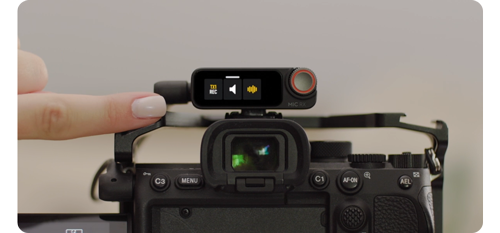 person using dji mic 2 receiver touchscreen control on mirrorless camera video rig