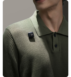 Person wearing knitted green polo shirt with DJI Mic Mini magnetic mounted
