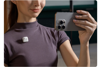 Young woman capturing video with apple iphone and white DJI Mic Mini 