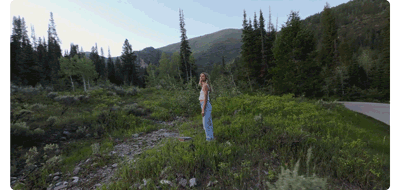 animated gif of woman standing on dirt path being circled by drone