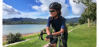 Image od woman sitting on road bicycle standing in grass park in front of lake