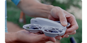 person holding DJI neo Drone in palm of their hand