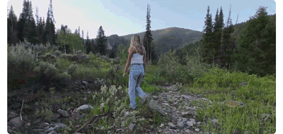 animated gif of woman walking in rocky meadow tracked by DJI Neo