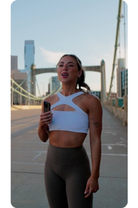 vertical photo of female fitness influencer standing on highway bridge