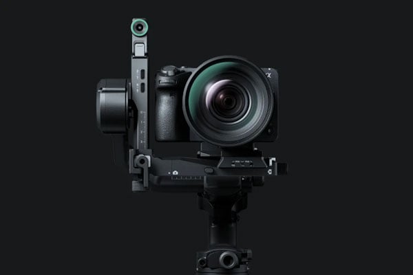 front view of a dlsr camera attached to the DJI RS 5 on a grey background