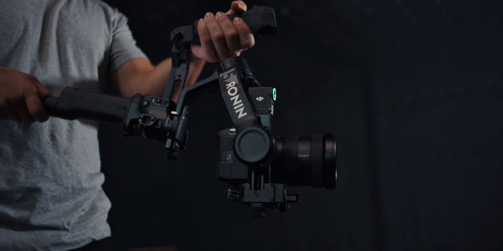 someone holding the DJI RS 5 on set by the new briefcase handle