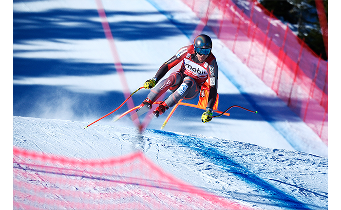 Fujifilm XF150-600mm Lens Sample Image Slalom Skiier cresting a hill and passing a checkpoint  in a race