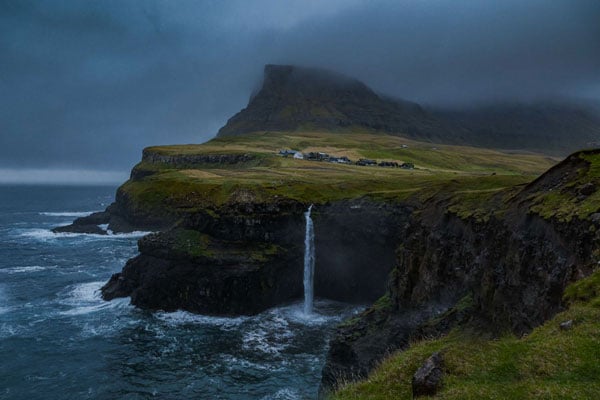 Fujifilm XF16-55mm F2.8 R LM WR II sample image of water fall at sea cliff edge in iceland covered with grassland and cloud