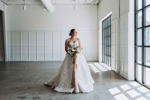 Fujifilm XF16-55mm F2.8 R LM WR II sample image of bride in wedding dress standing in large white walled garage room