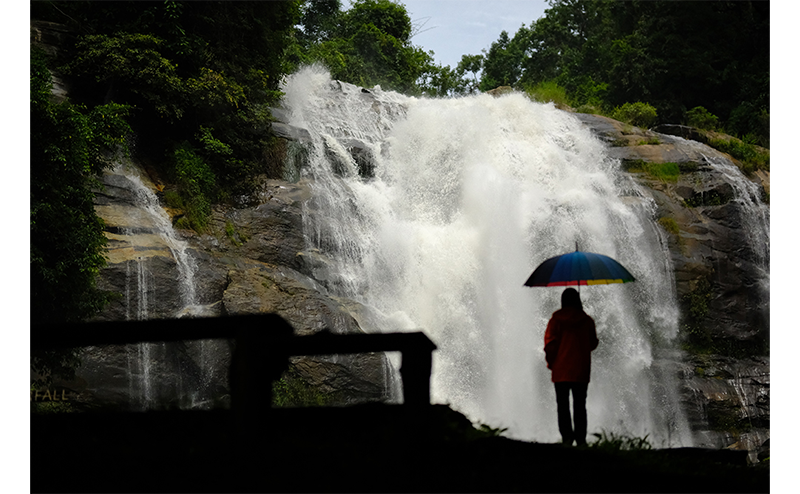 Fujifilm Fujinon XF56mm Lens sample image of person with umbrella stood in front of a roaring waterfall