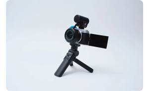image of Fujifilm X-M5 mounted on mini tripod with sennheiser video microphone on white background