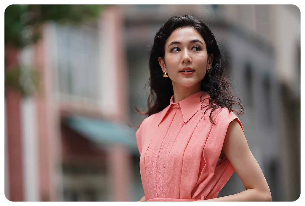 Sony A7C Sample image of black haired woman wearing soft pink dress standing in the street