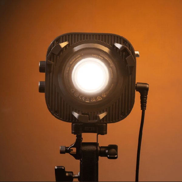 front view of the amaran monolight turned on against a orange background