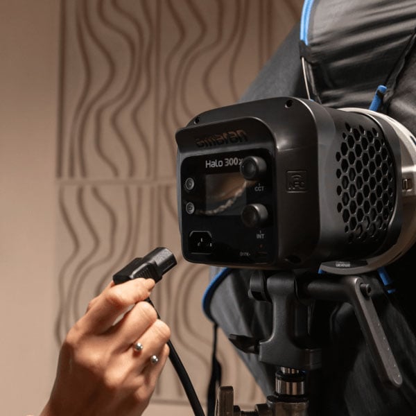someone connecting a power cable into the amaran monolight