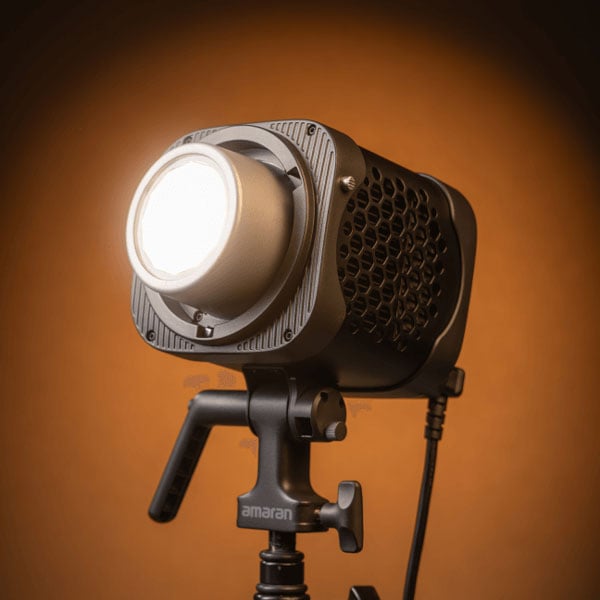 angled view of the amaran monolight on a stand infront of an orange background