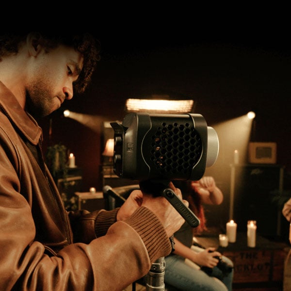 someone attaching the amaran monolight to a light stand in a studio