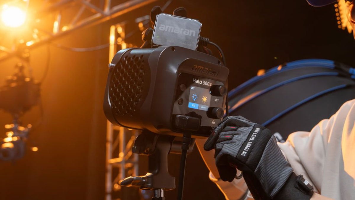 someone adjust the controls on the amaran monolight in a studio