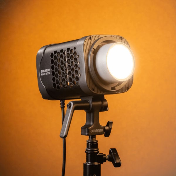 angled view of the amaran monolight on a stand infront of an orange background