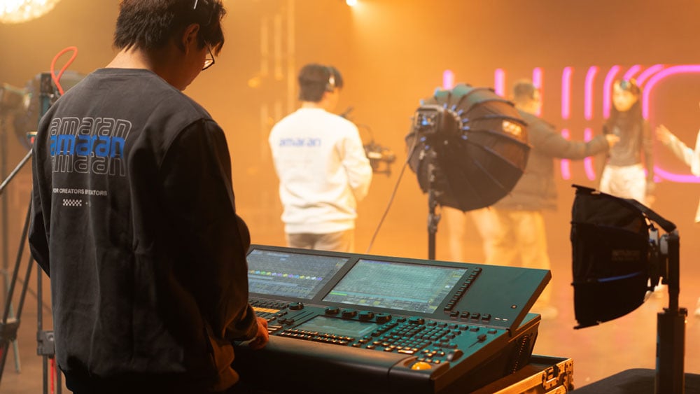 somone behind a control desk adjusting the amaran monolight