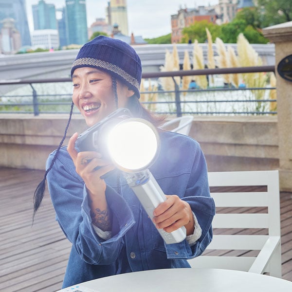 somone sat at a table at a river front holding the amaran light
