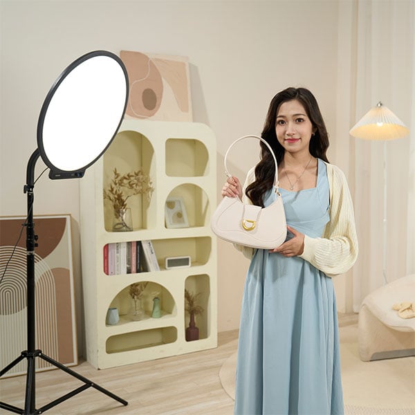 a woman holding a bag stood in front of the amaran panel light