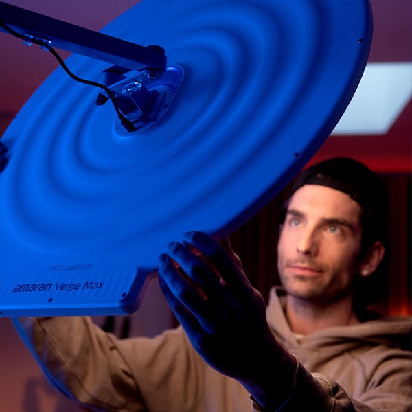 someone adjusting the amaran panel light on set