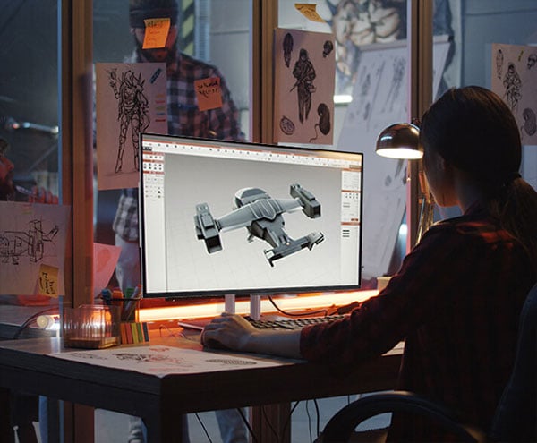 game developer sat at a desk 3d modelling on the asus proart display