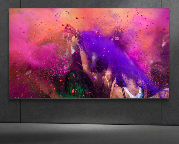 asus pro art cinema display mounted on a grey wall showing people in a paint fight
