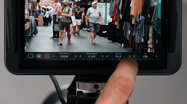 someone controlling a camera on the atomos shinobi 7