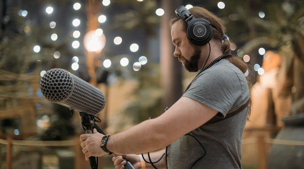 audio technican using a boom mic and headset