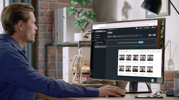 someone sat a desk working on footage using atomos cloud