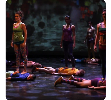performers on stage acting performing a dance routine with visual effects projected onto the stage wall and floor