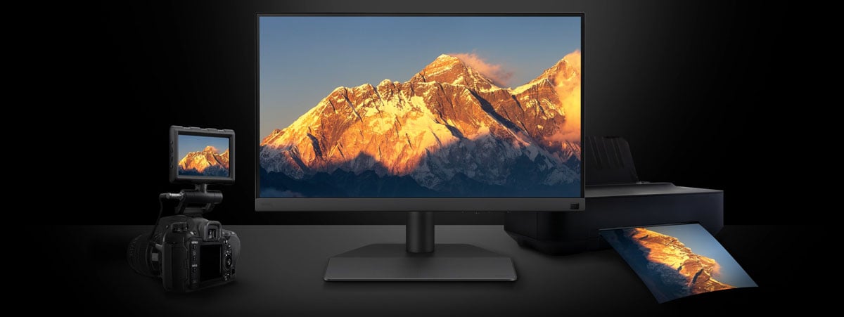 benq monitor on a desk with a camera and printer
