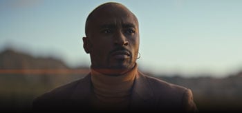 African american actor wearing brown turtle neck and suit jacket