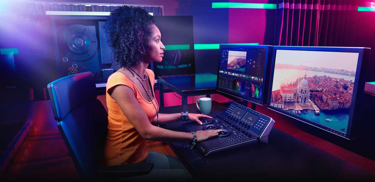 Video editor working with DaVinci Resolve Studio using micro colour panel grading footage of Venice
