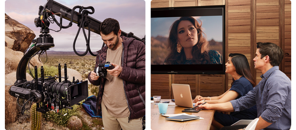 Camera operator and video executives reviewing footage on cinema display