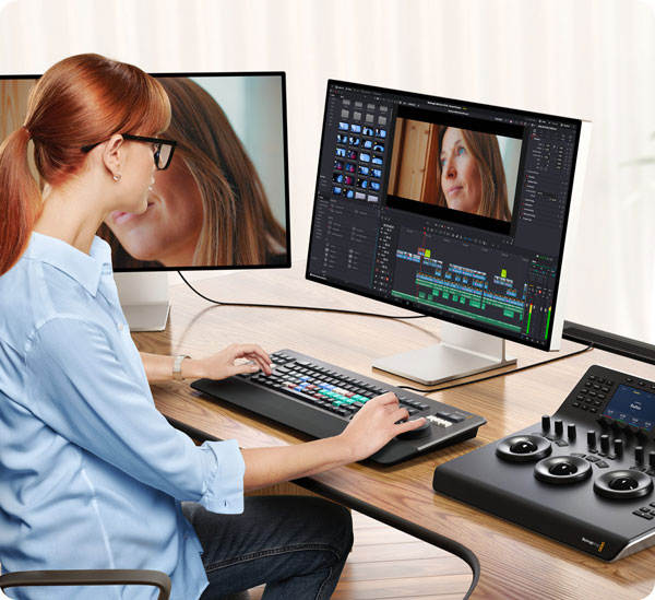 a woman sat at a desk editing footage in resolve